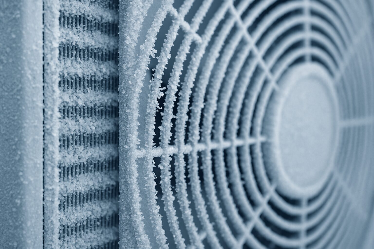 Givre sur la batterie et la grille du ventilateur d’une PAC en hiver.